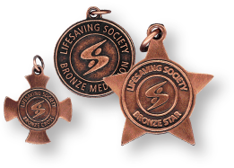 Three bronze medals from the Lifesaving Society, featuring the organization's logo: a circular Bronze Medallion, a star-shaped Bronze Star, and a cross-shaped Bronze Cross.